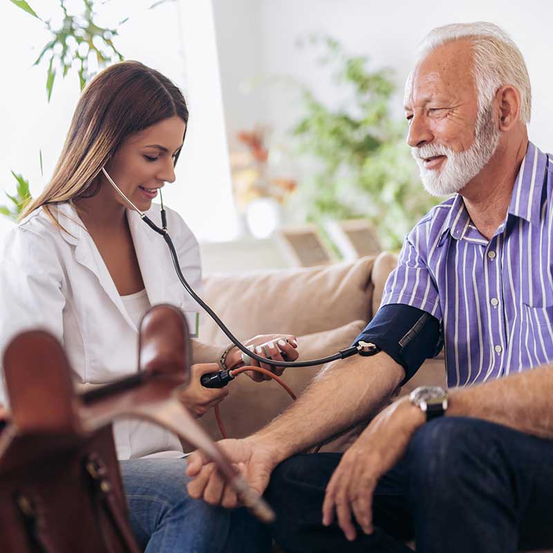 nurse-checking-blood-pressure-of-senior-man-in-home-cls-and-respite-care-services-integrated-living nurse-checking-blood-pressure-of-senior-man-in-home-cls-and-respite-care-services-integrated-living
